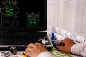 Engineer at Computer with Drawings